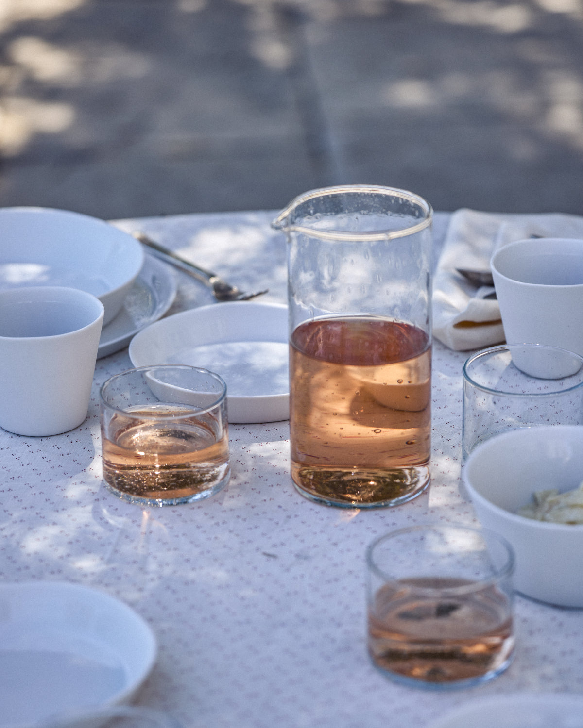Blau-türkises Keramikgeschirr mit Datteln auf rustikalem Stein im Garten